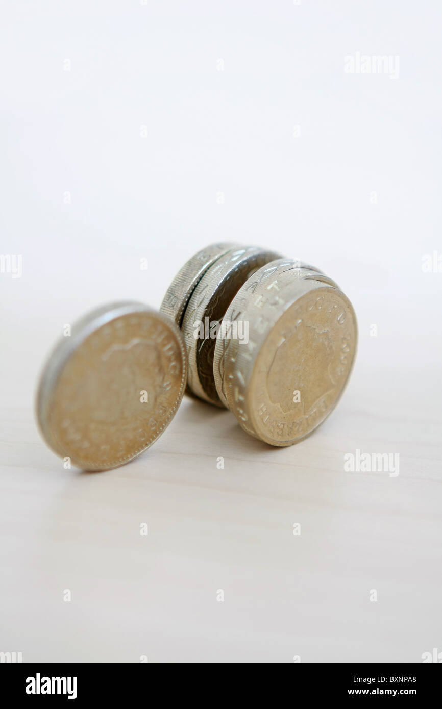 Una fila di sterling £1 monete su estremità con one £ 1 gettone allentata Foto Stock