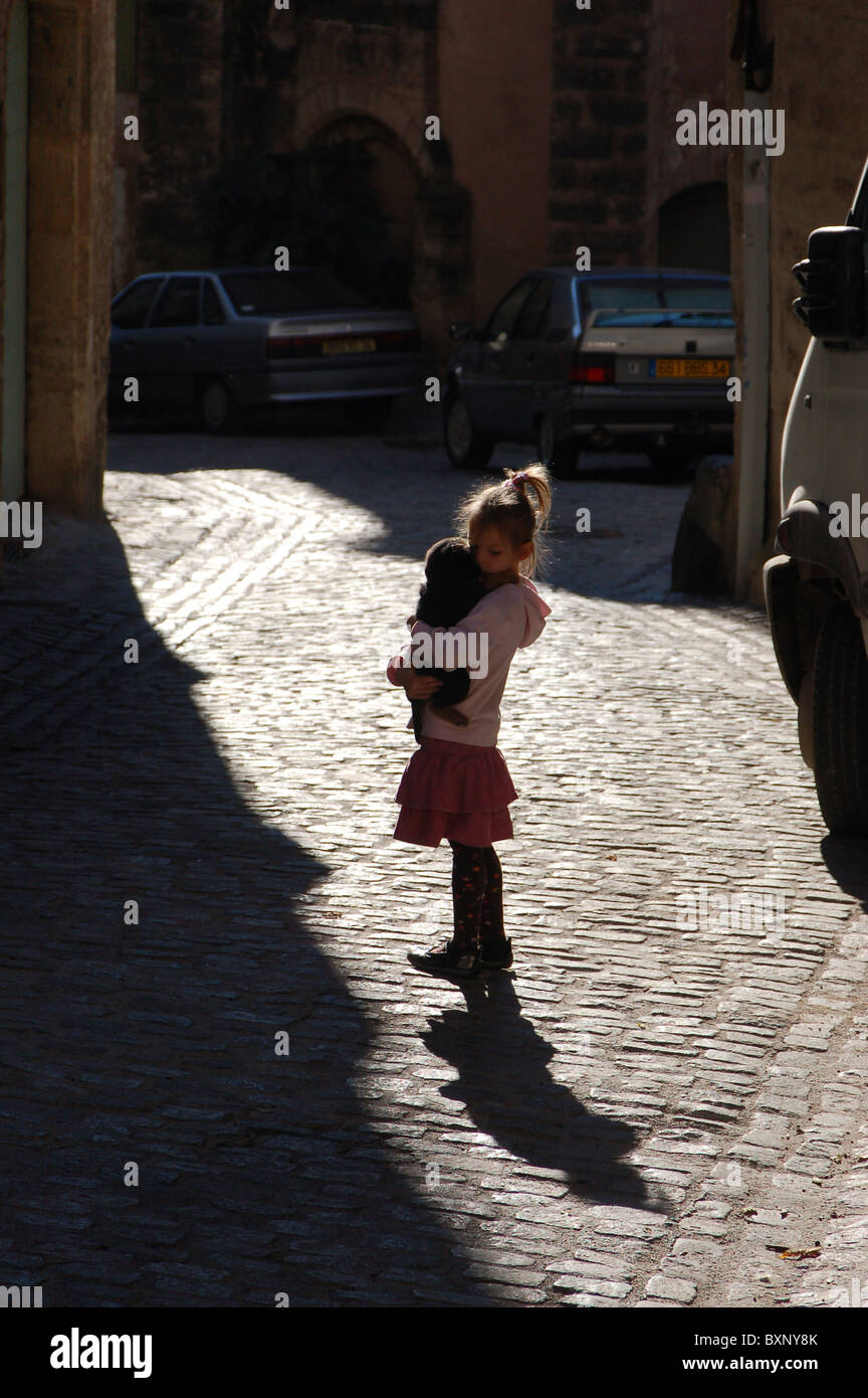 Bambina nel sole e shaddows della strada di ciottoli a Pezenas, Francia Foto Stock