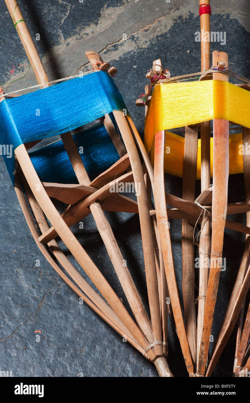 Seta colorata thread su mandrini di bambù utilizzata su un telaio per la realizzazione di sari. Andhra Pradesh, India Foto Stock