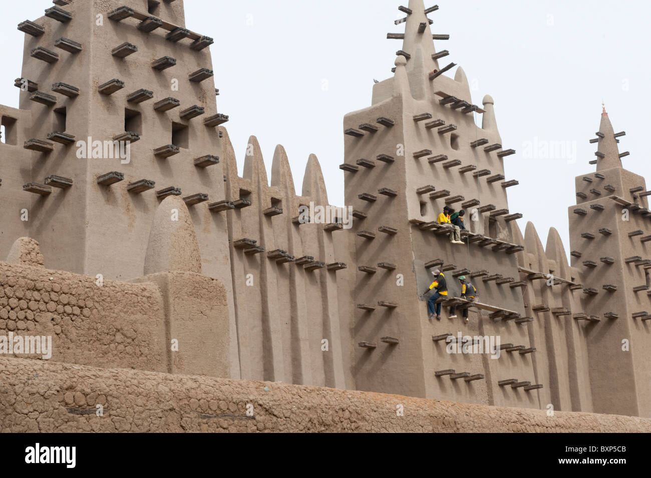 I lavoratori della 'Aga Khan trust per la cultura " riparazione l'intonaco della grande moschea di Djenné, Mali Foto Stock