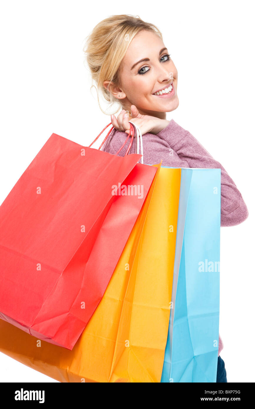 Attraente giovane donna bionda di caricarti di Multi-Colored Shopping Bags cercando felice ed entusiasta Foto Stock