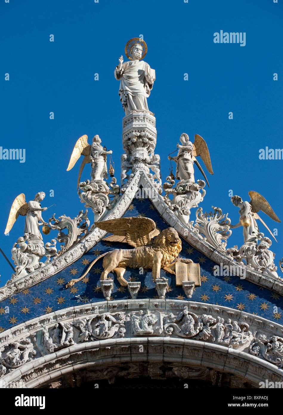 San Marco statua e leone alato sulla sommità della facciata della basilica di San Marco, Venezia, Italia Foto Stock