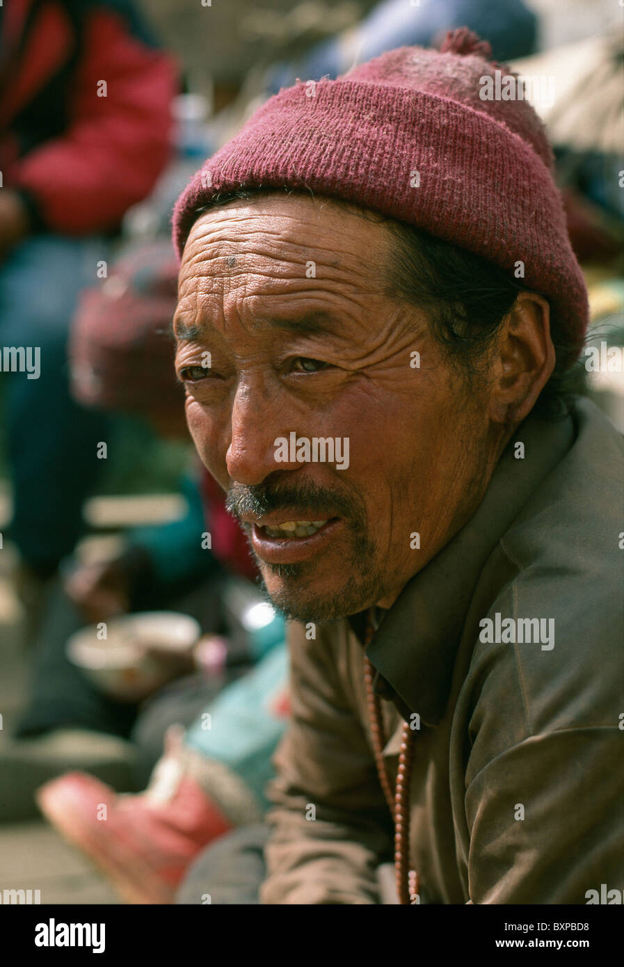 Un uomo tibetano e rifugiato riposa dopo aver camminato attraverso la frontiera Tibetan-Chinese in montagna himalayana in Nepal. Foto Stock