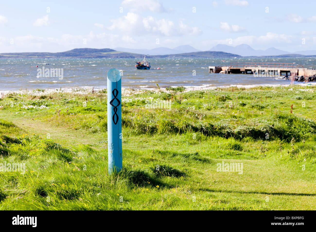 Un waymarking post per il modo di Kintyre a Tayinloan sulla penisola di Kintyre, Argyll & Bute, Scozia. Gigha e Jura sono visibili Foto Stock