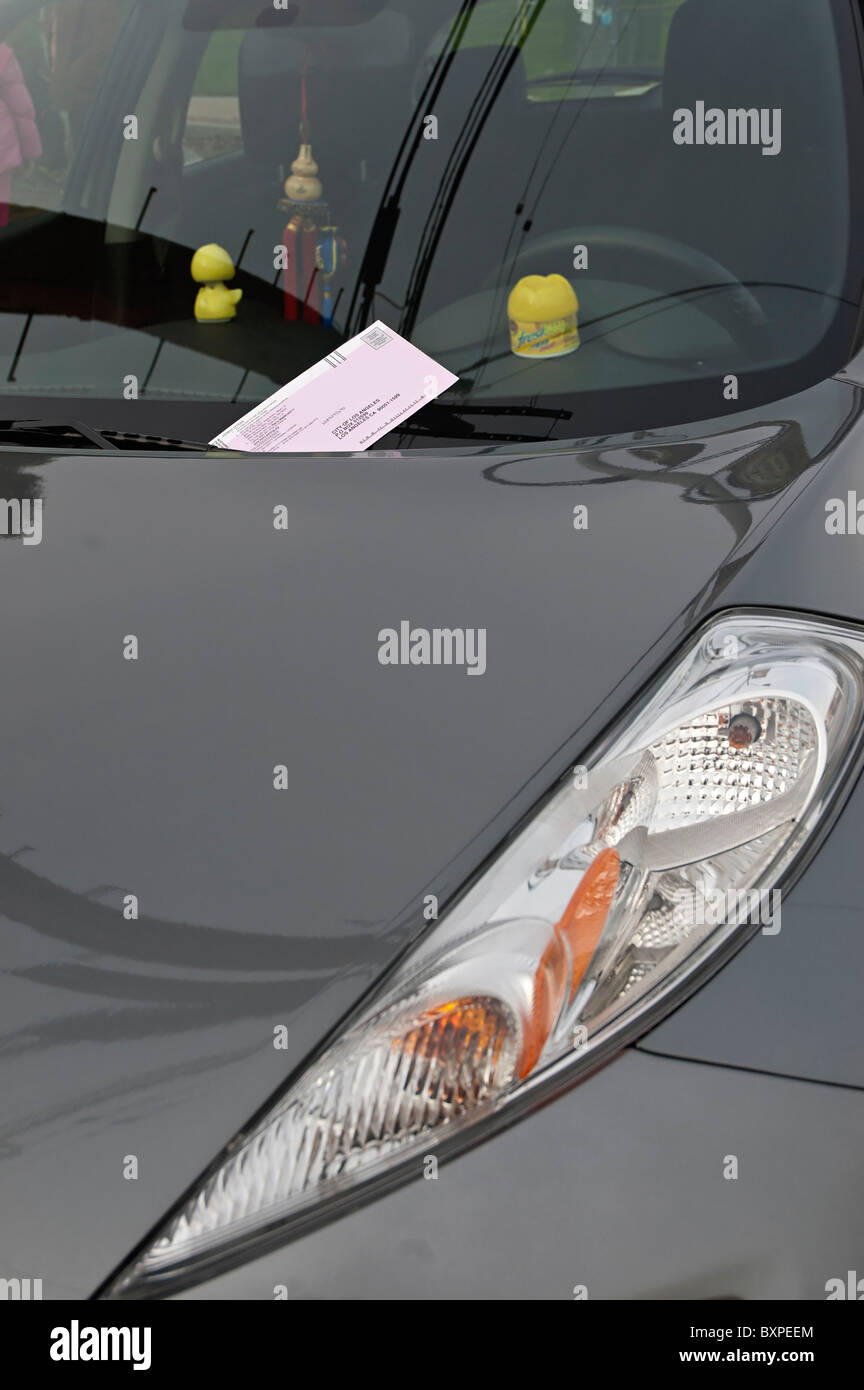 Una vettura con un parcheggio ticket rilasciato a causa di un misuratore di scaduta. Foto Stock