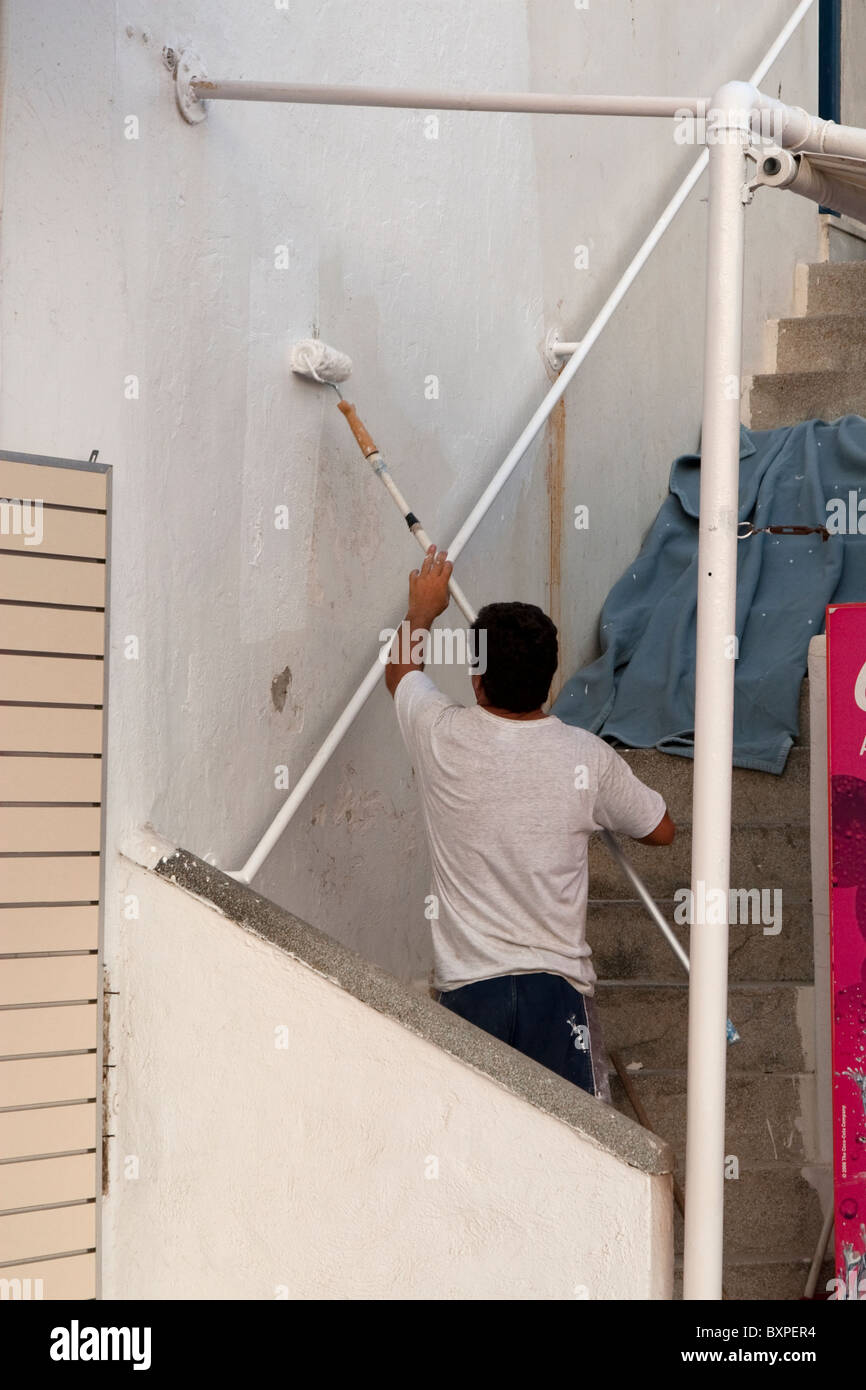 Uomo locale dipinto sulla parete della sua casa bianca, Mykonos, CICLADI Foto Stock