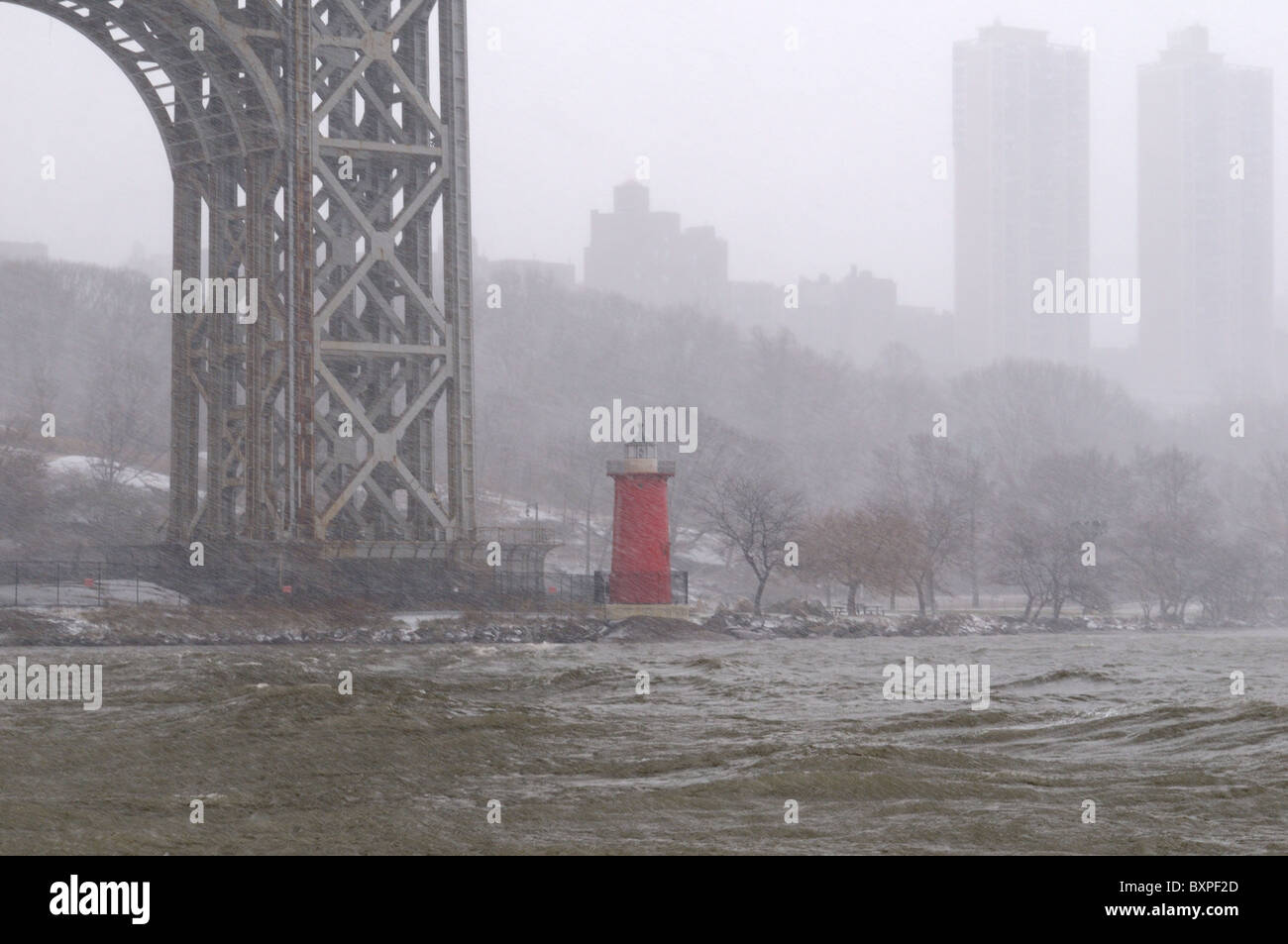 Neve spazzate dal vento pummeled il piccolo faro rosso a Jeffrey's gancio sotto il Ponte George Washington Bridge. Dic. 26, 2010. Foto Stock