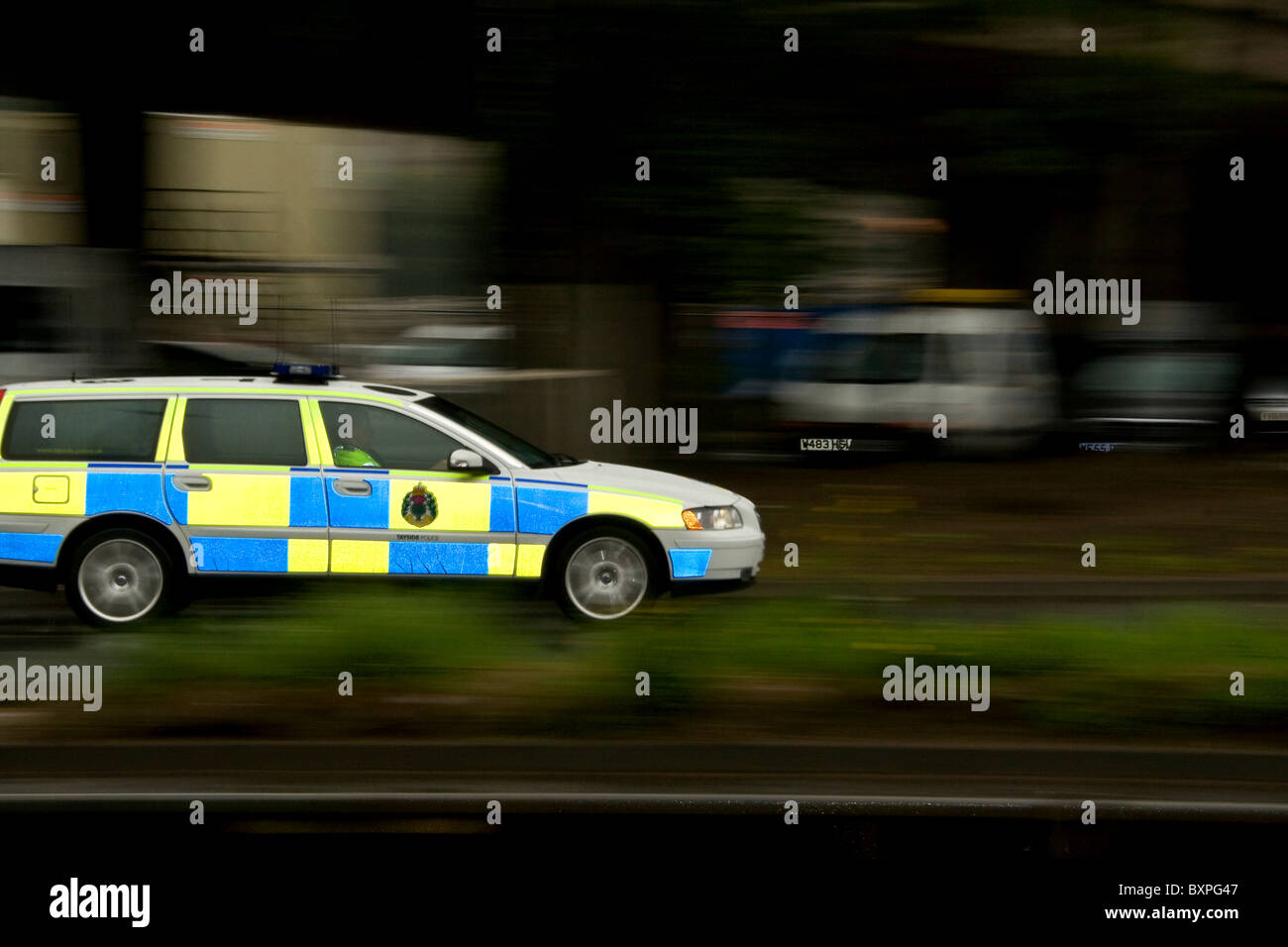 Panning con il flash posteriore di sincronizzazione di un'automobile della polizia di Tayside (ora la Scozia della polizia) mentre accelera intorno ad una rotonda in Dundee urbano, Regno Unito Foto Stock