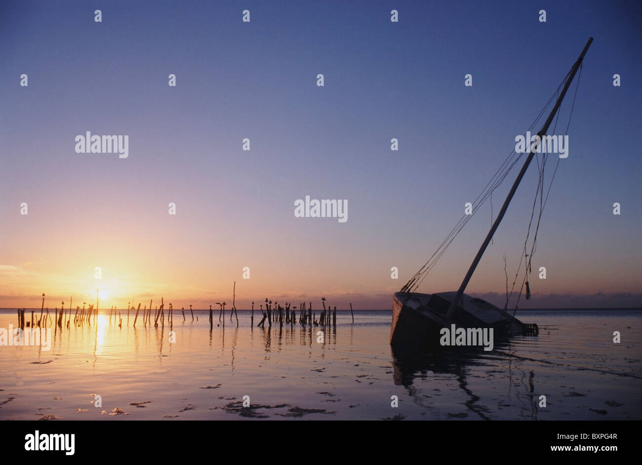 Parzialmente sommerse e Keeling barca vela in Silhouette al tramonto Foto Stock