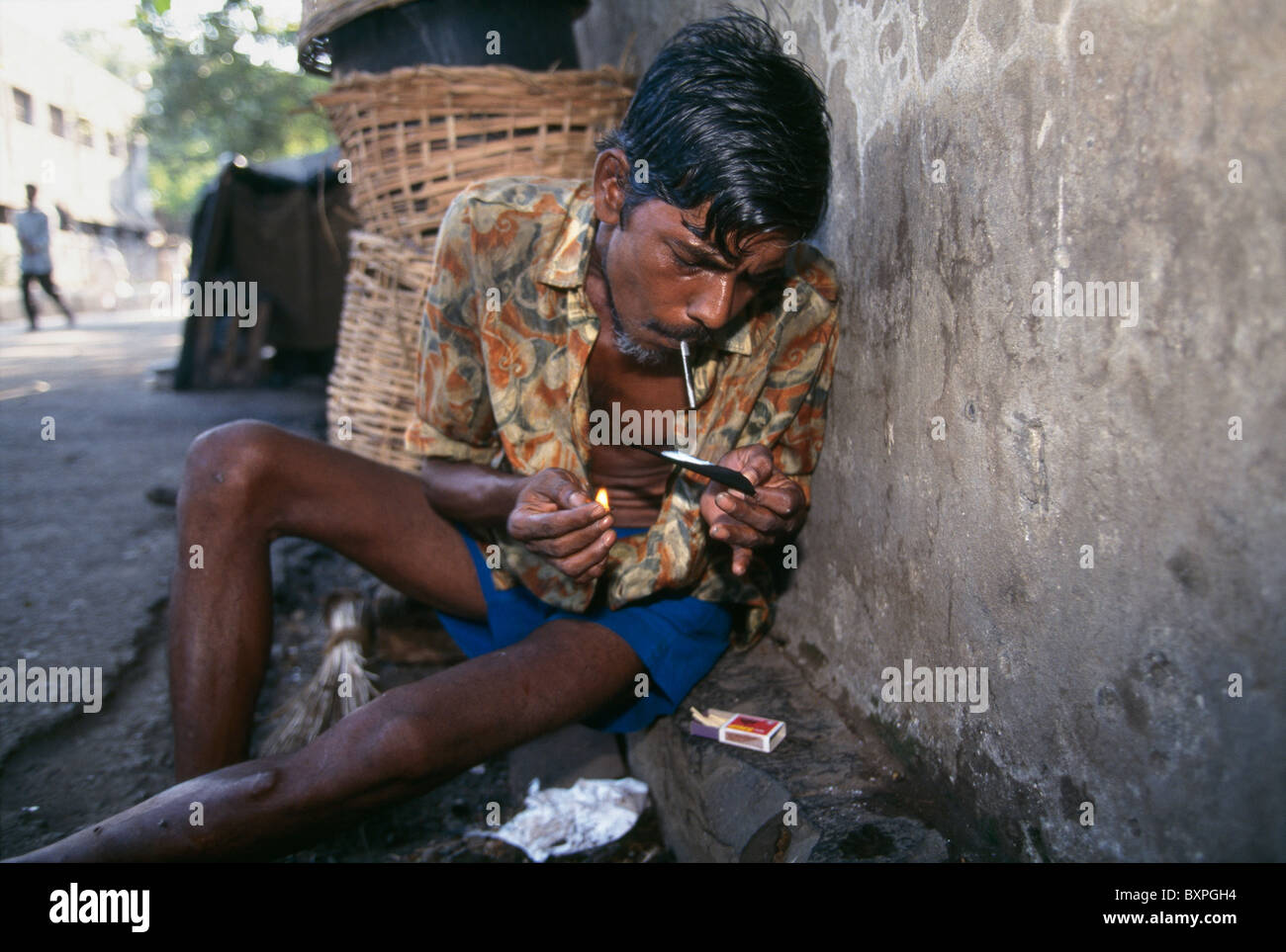 Un maschio tossicodipendente fuma eroina o 'insegue il drago" sulle strade di Mumbai, India. Foto Stock