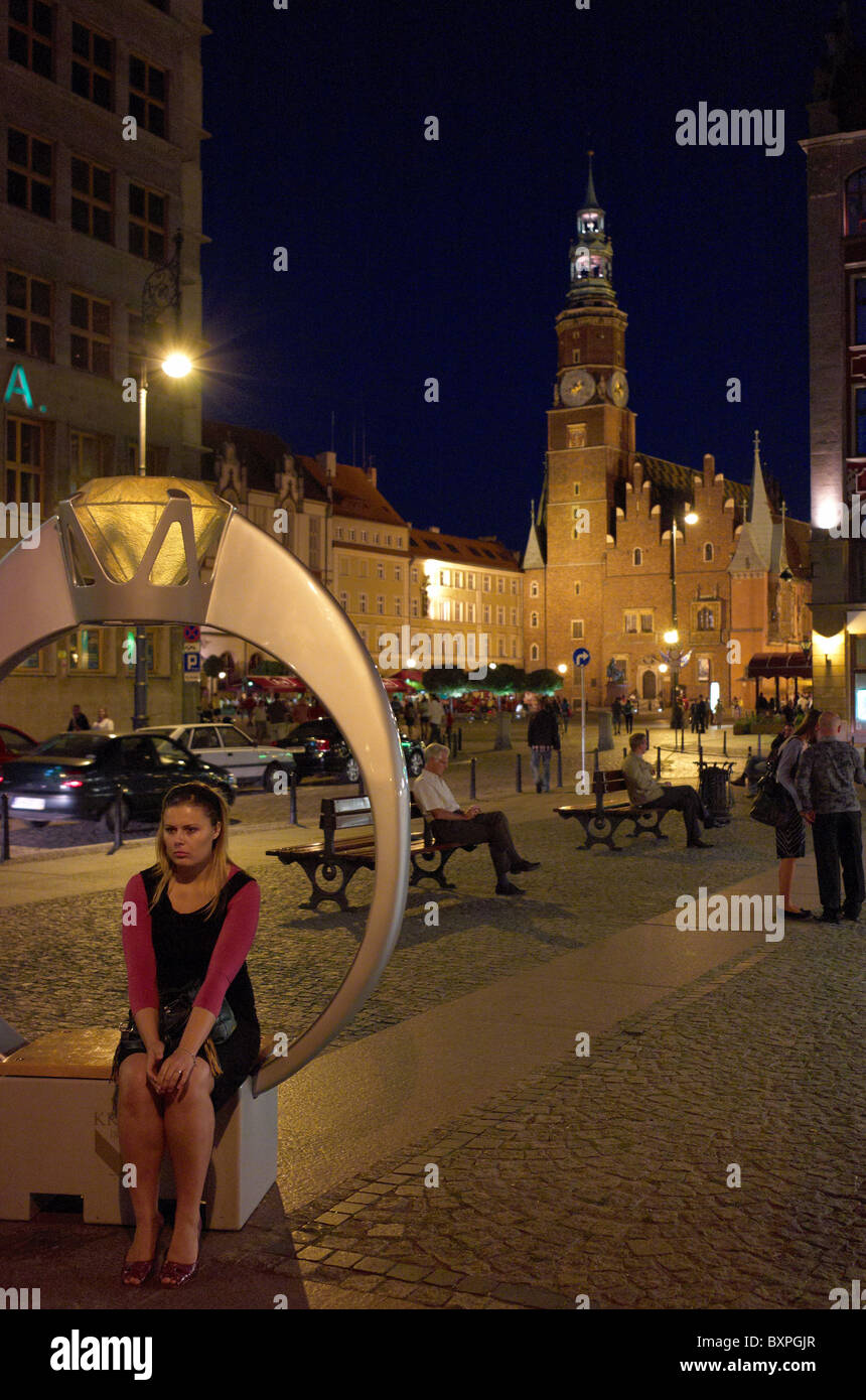 Donna seduta in un grande anello stilizzato, Wroclaw, Polonia Foto Stock