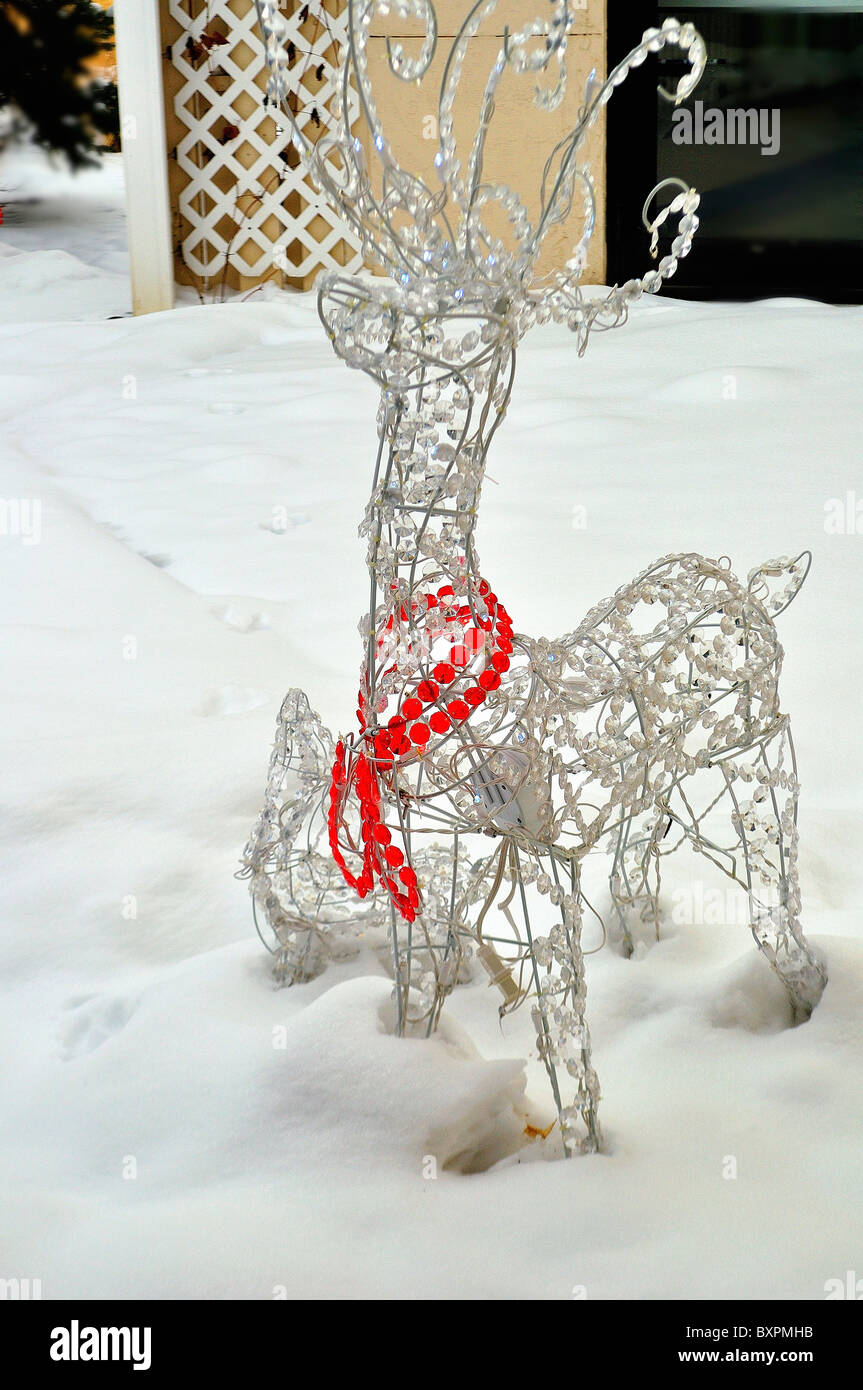 Cervi decorativo di luci e di nastro seduta nella neve in un cortile in dicembre. Foto Stock