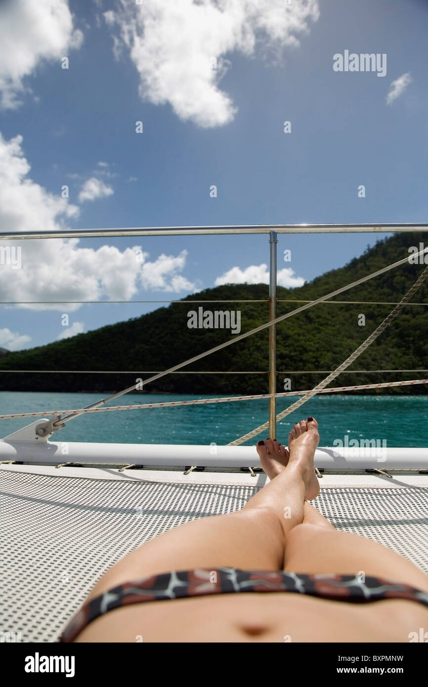Sunbather in Bikini a prendere il sole sulla barca a vela e a basso angolo di visione Foto Stock