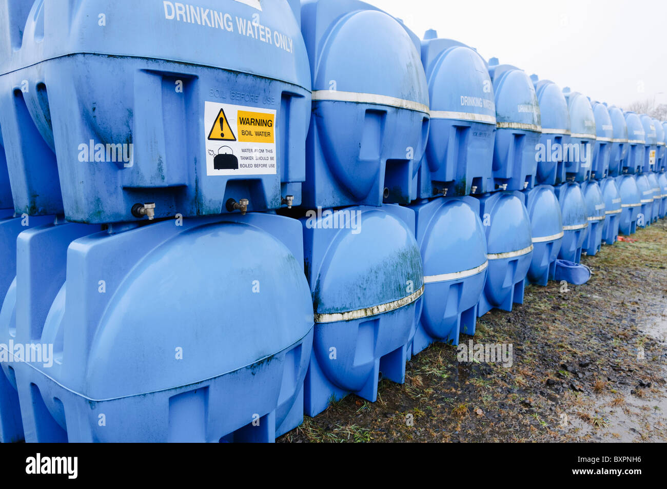 Blu acqua potabile serbatoi di stoccaggio (bowsers) in deposito in attesa di distribuzione in un'emergenza acqua situazione di carenza Foto Stock