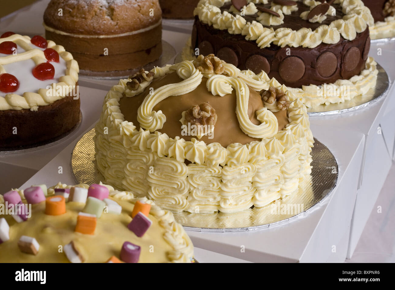 Una selezione di torte decorate in stallo del mercato Foto Stock