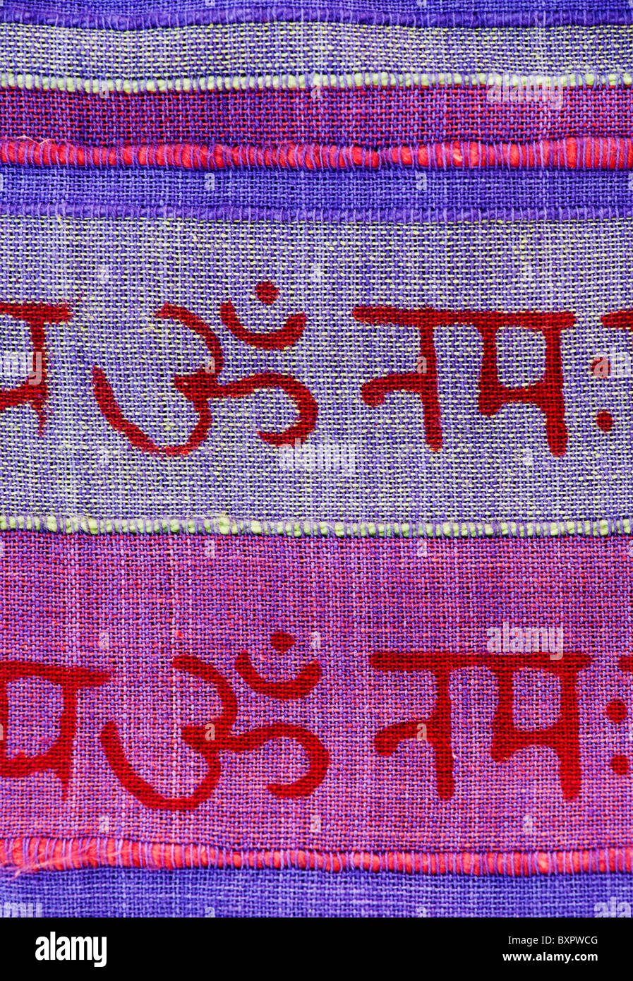 OM e hindi iscritto sulla colorata materiale indiano. India Foto Stock