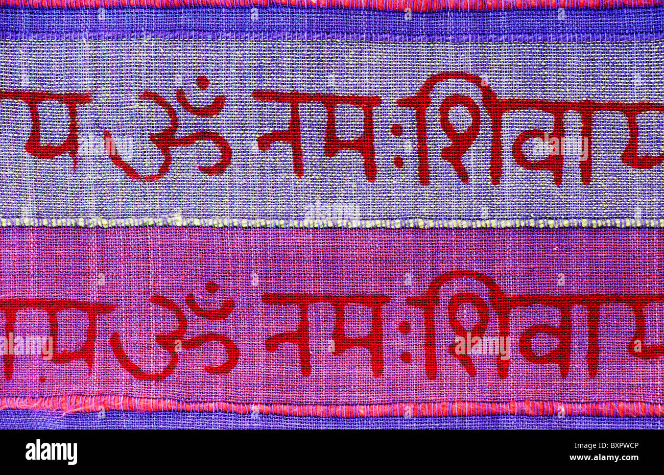 OM e hindi iscritto sulla colorata materiale indiano. India Foto Stock