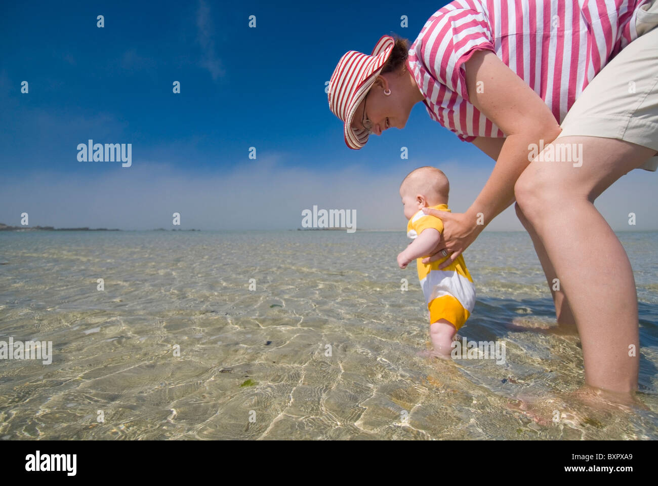 La madre e il bambino in acque poco profonde lungo la spiaggia, a basso angolo di visione Foto Stock