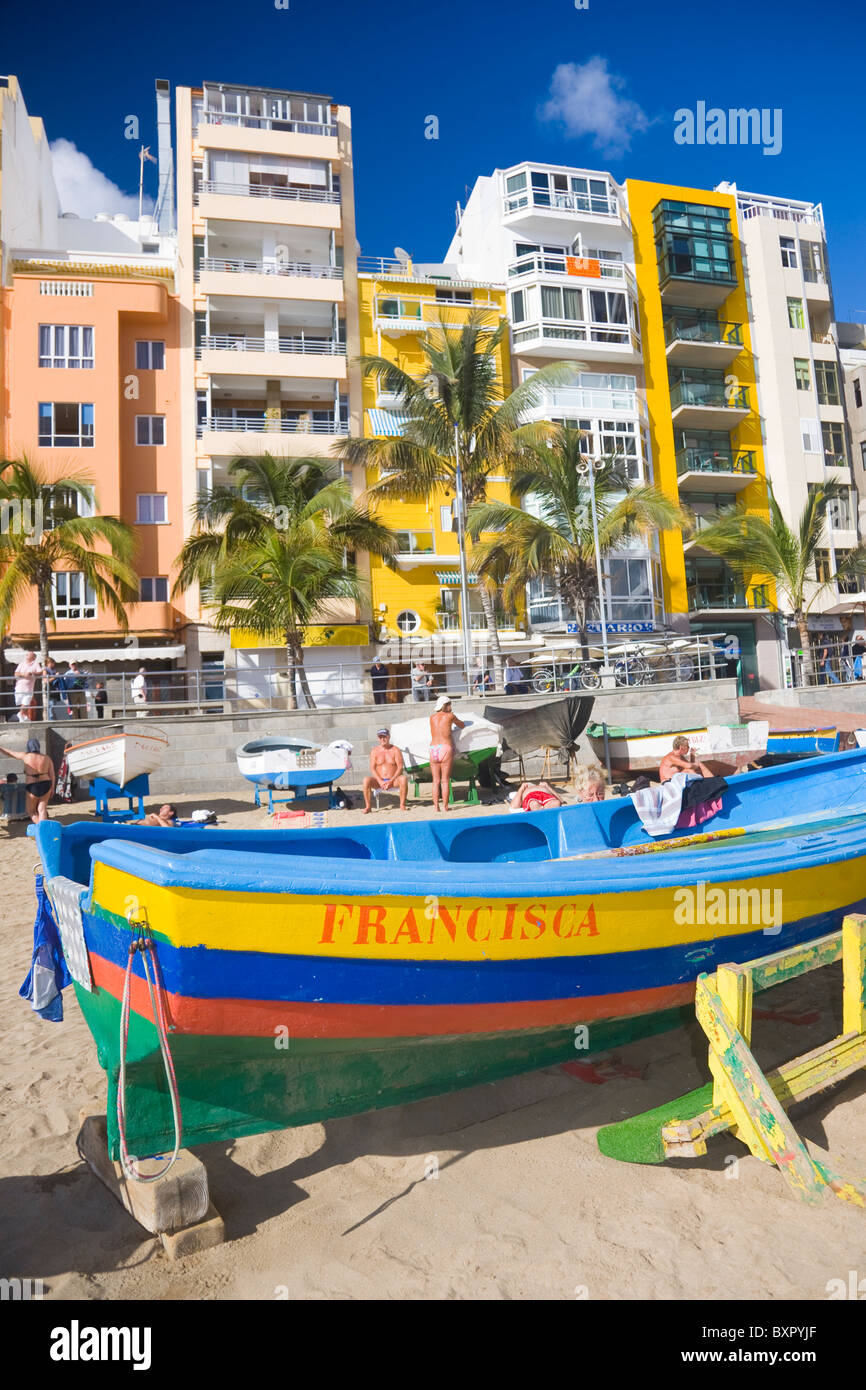 Vista di Las Canteras beachfront in Las Palmas de Gran Canaria con una colorata barca da pesca in primo piano. Foto Stock