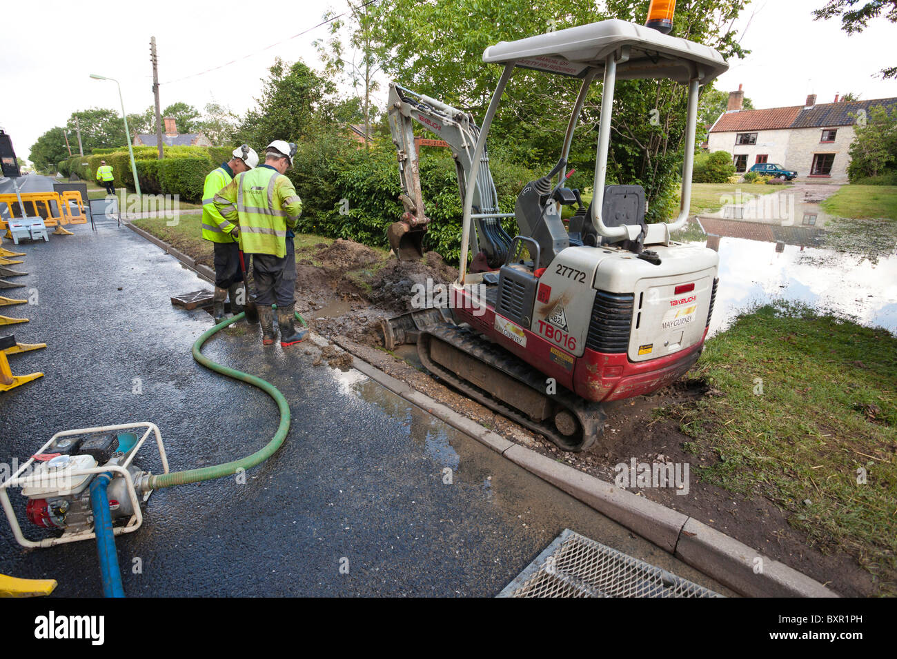 I lavoratori da maggio GURNEY scavando un foro accanto a una strada per la riparazione di un burst la rete idrica della canalizzazione di alimentazione Foto Stock