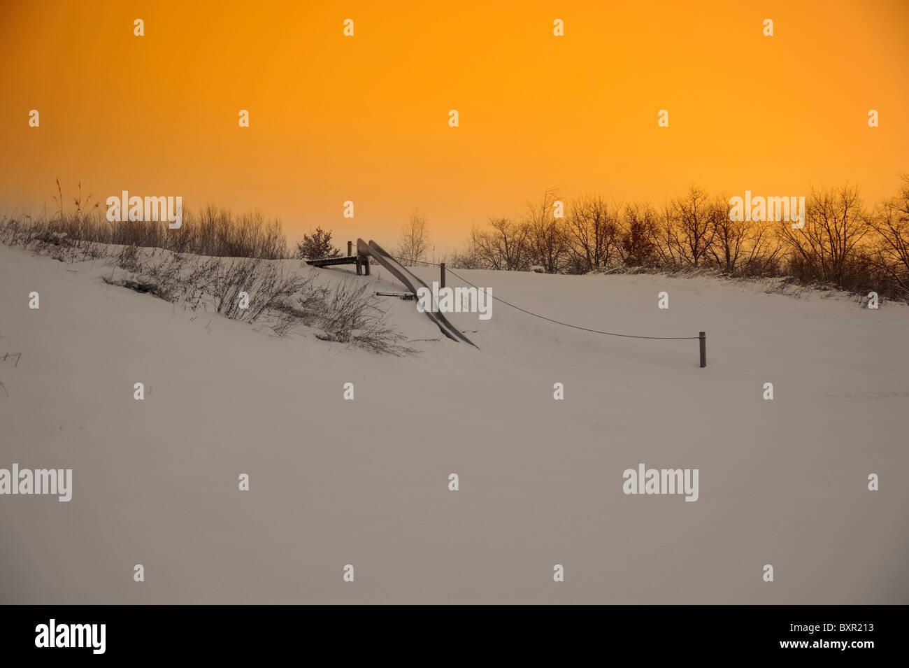 Una coperta di neve parco giochi diapositiva all'inizio inverno mattina Foto Stock