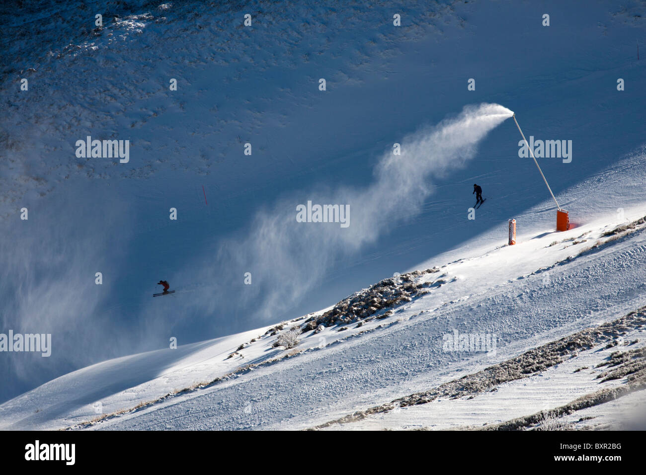 Un cannone da neve e gli sciatori al Mont-Dore inverno ski resort (Auvergne - Francia). Canon à neige et skieurs au Mont-Dore. Foto Stock