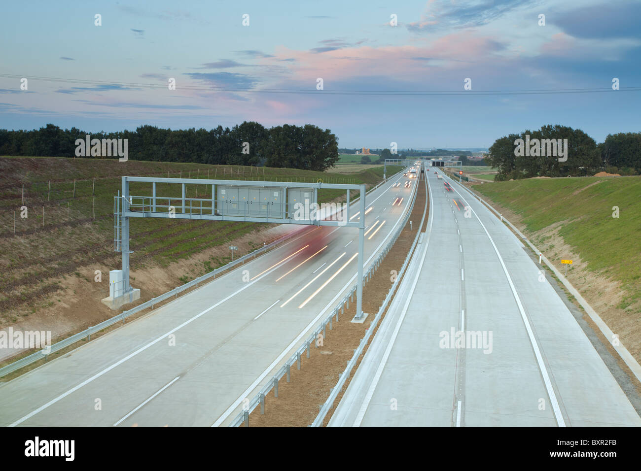 Autostrada al crepuscolo con veicoli in movimento e vista del paesaggio nella Repubblica Ceca. Foto Stock