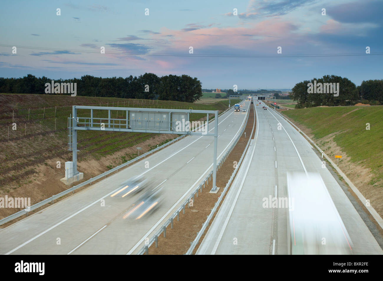 Autostrada al crepuscolo con veicoli in movimento e vista del paesaggio nella Repubblica Ceca. Foto Stock