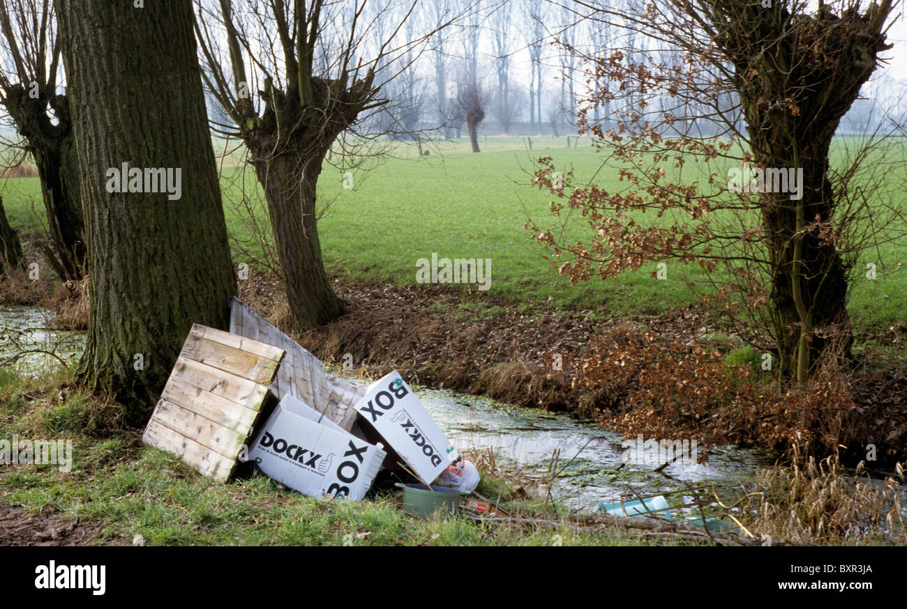 Scarico illegale di scatole scartato vicino brook nel campo Foto Stock
