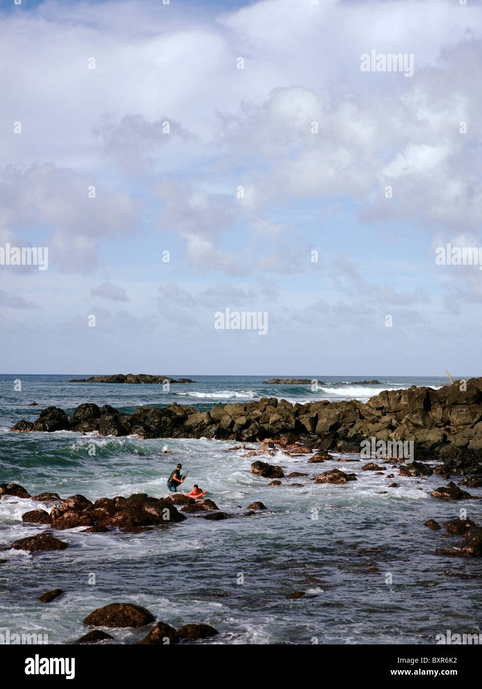 Surfers off la costa orientale a Oahu, Hawaii Foto Stock