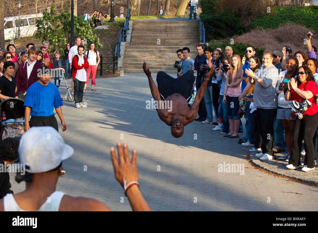 Performer di strada facendo capriole in Central Park per una folla di New York City Foto Stock