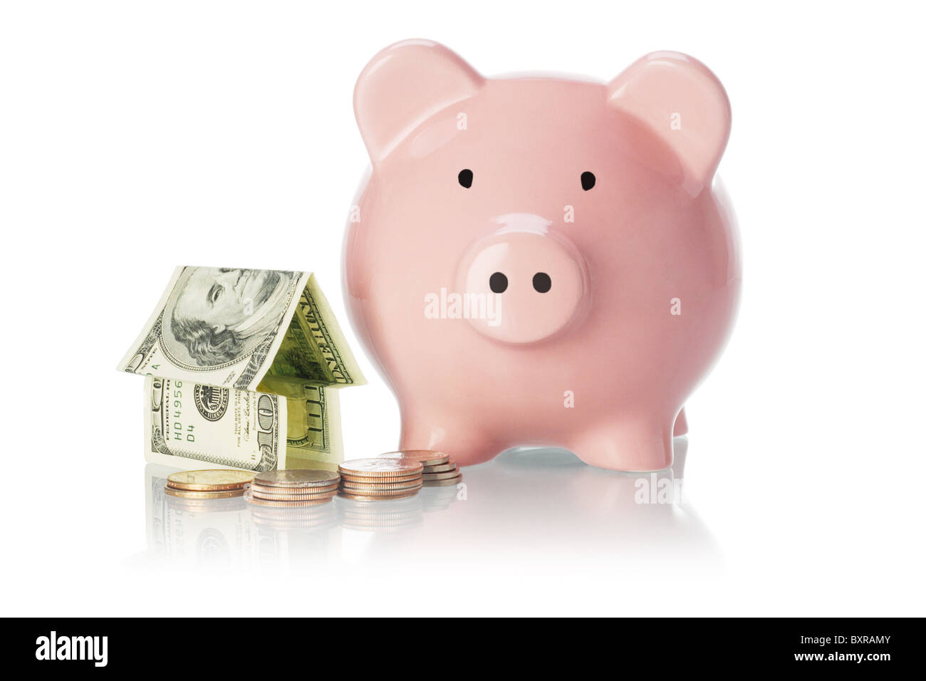 Di risparmio e di investimento - salvadanaio, casa di denaro e monete su sfondo bianco Foto Stock