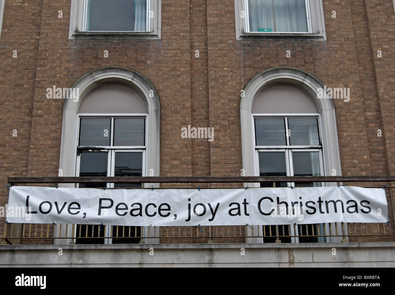 Amore, Pace e gioia a Natale banner su un balcone del regno chiesa riformata a Kingston upon Thames Surrey, Inghilterra Foto Stock