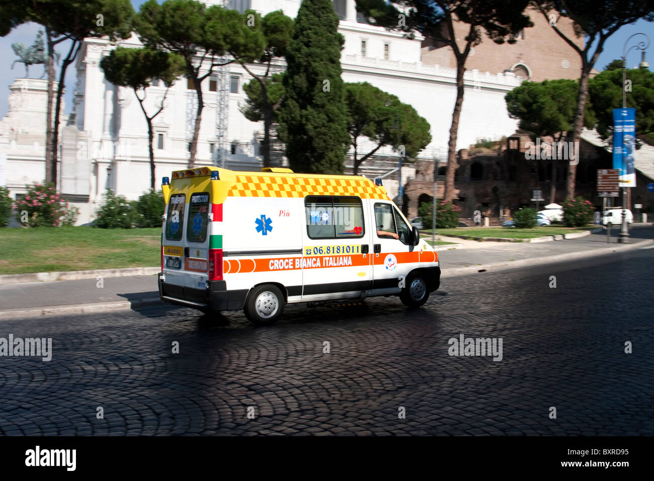 Ambulanza lungo Via de San Venanzio con il monumento a Vittorio Emanuele II in background, Roma, Italia Foto Stock