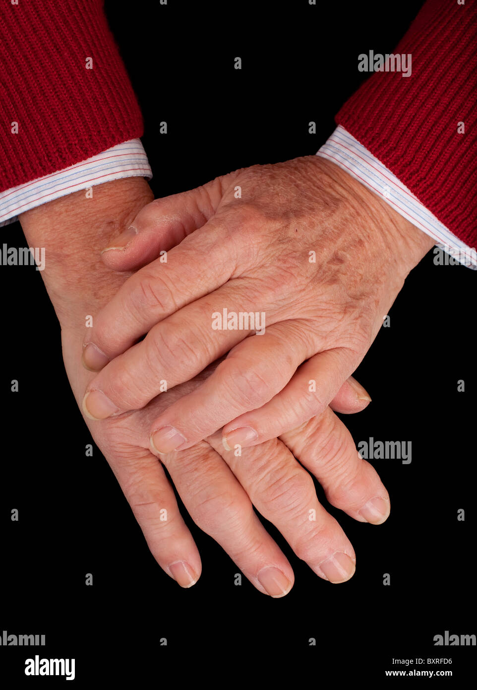 Artritico mani di una donna senior su uno sfondo nero. Foto Stock