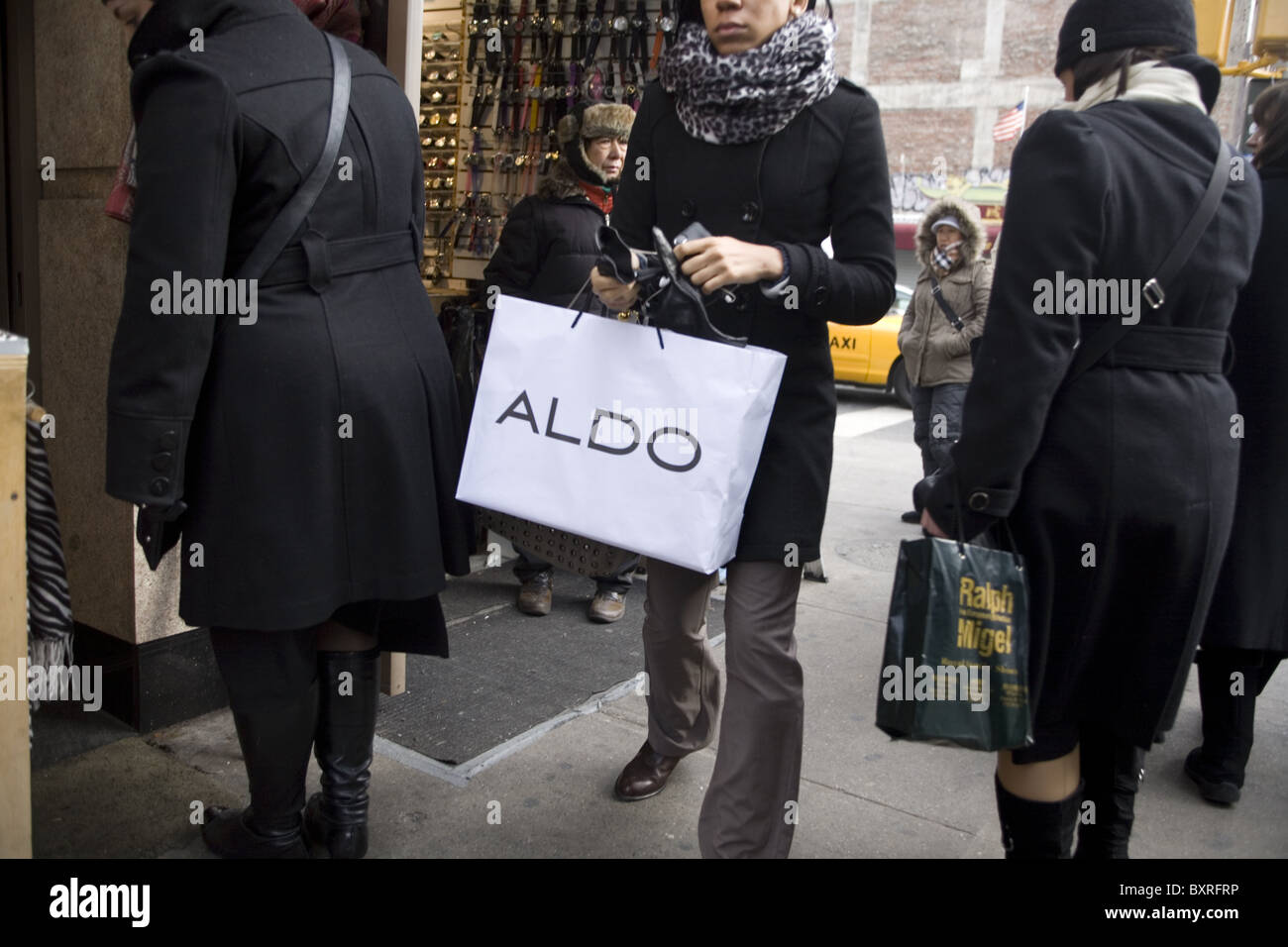 Le donne a piedi con il designer di etichette su loro borse per lo shopping nel cuore di Manhattan. Foto Stock
