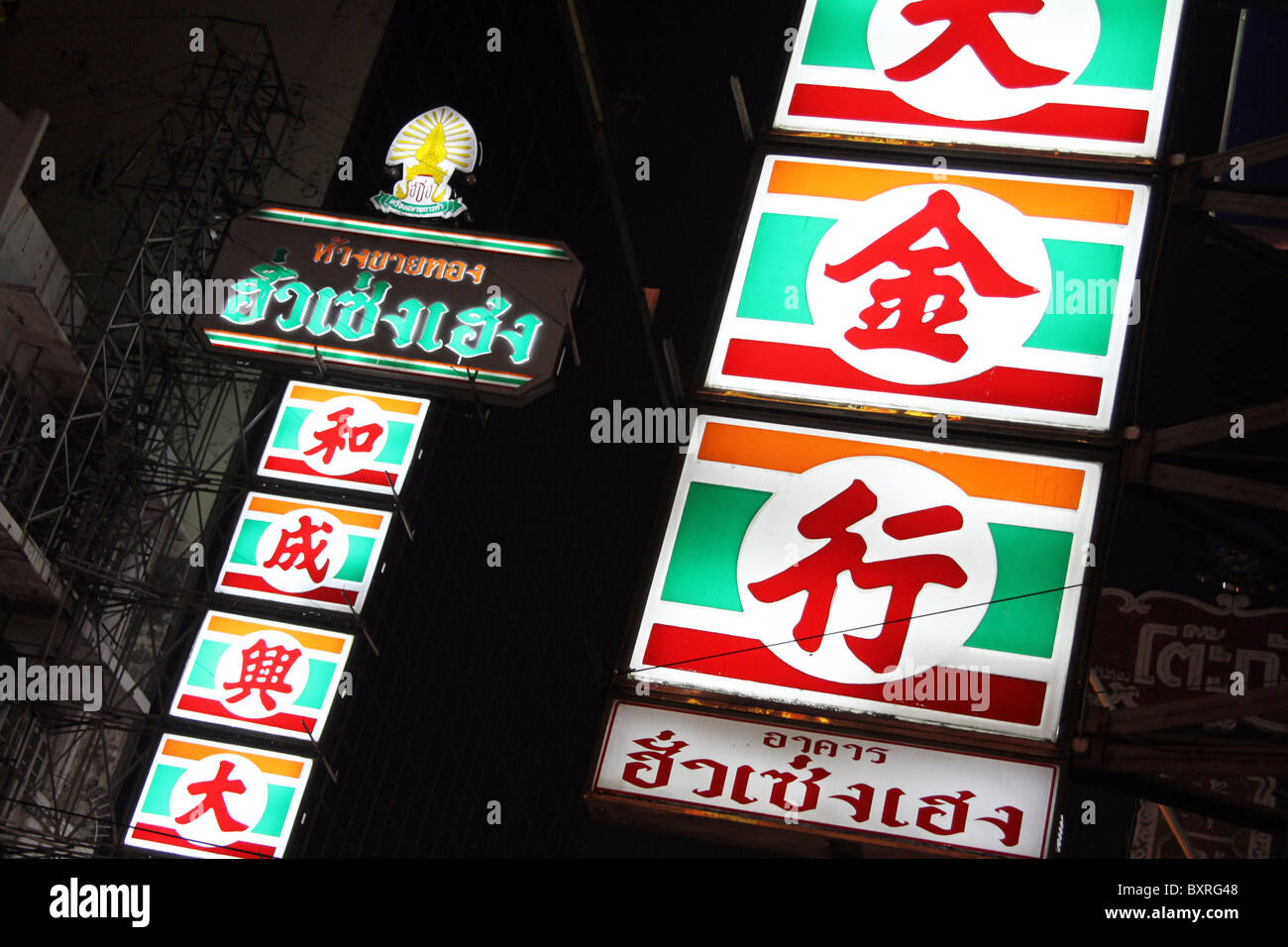 Luci al neon e segni con i cinesi e thailandesi i caratteri di scrittura in Chinatown a Bangkok, in Thailandia Foto Stock