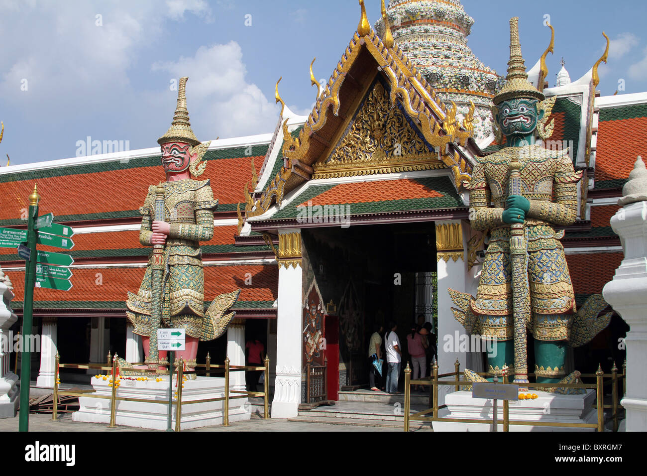 Di colore verde e rosa di fronte statue giganti al Wat Phra Kaeo (Kaew) tempio complesso del Tempio del Buddha di Smeraldo di Bangkok, Th Foto Stock