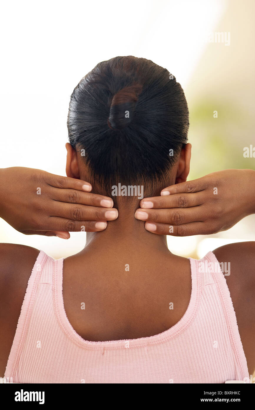 La donna in rosa giubbotto, parte posteriore della testa e spalle, mani in corrispondenza di entrambi i lati del collo, punte delle dita premendo leggermente Foto Stock