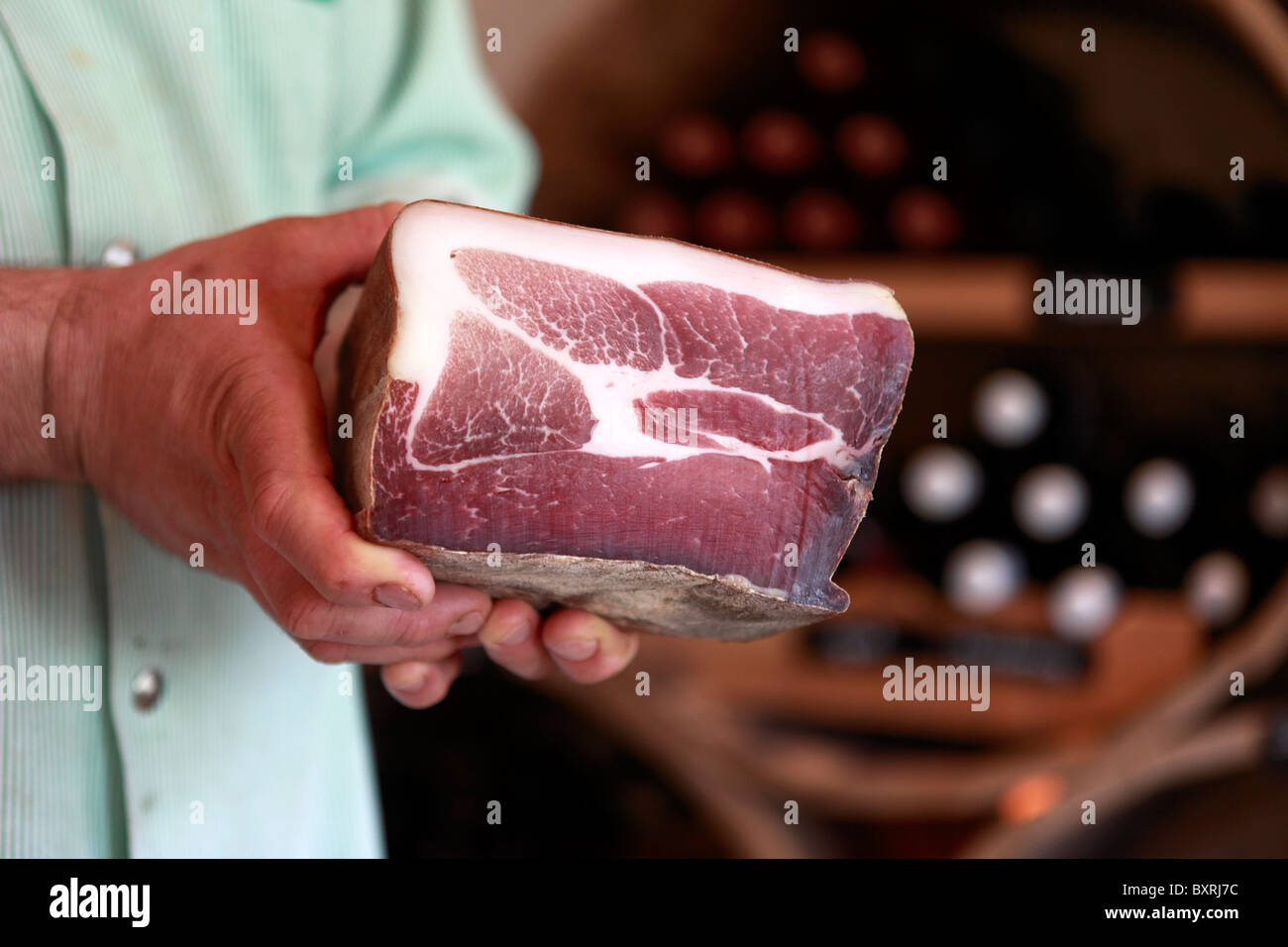 Un macellaio detiene il taglio di carne essiccata presso la norcineria di Val d'Anniviers in Vissoie, Svizzera Foto Stock