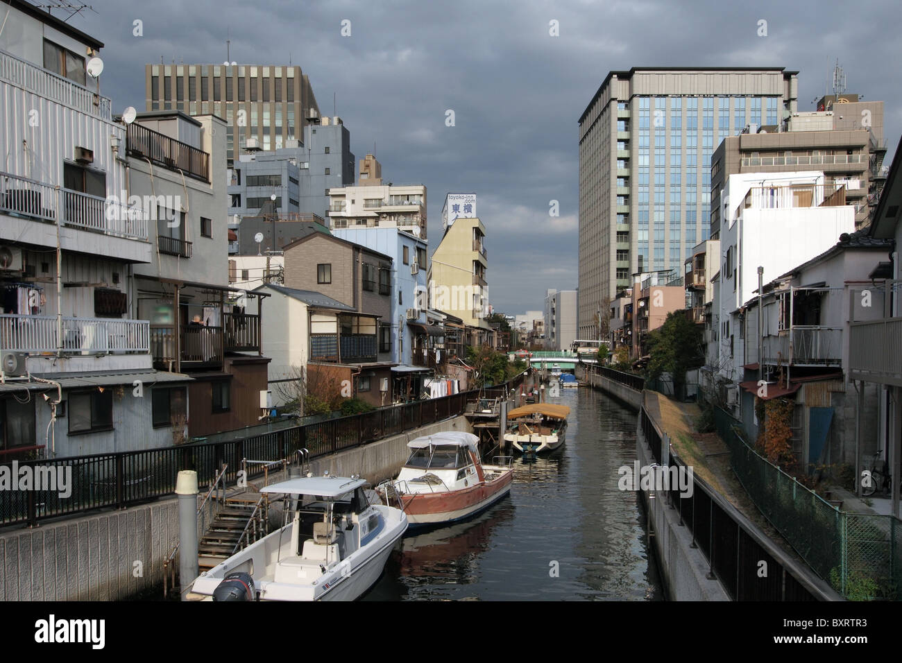 Proprietà di alloggiamento su un fiume canal a Tokyo Giappone Foto Stock