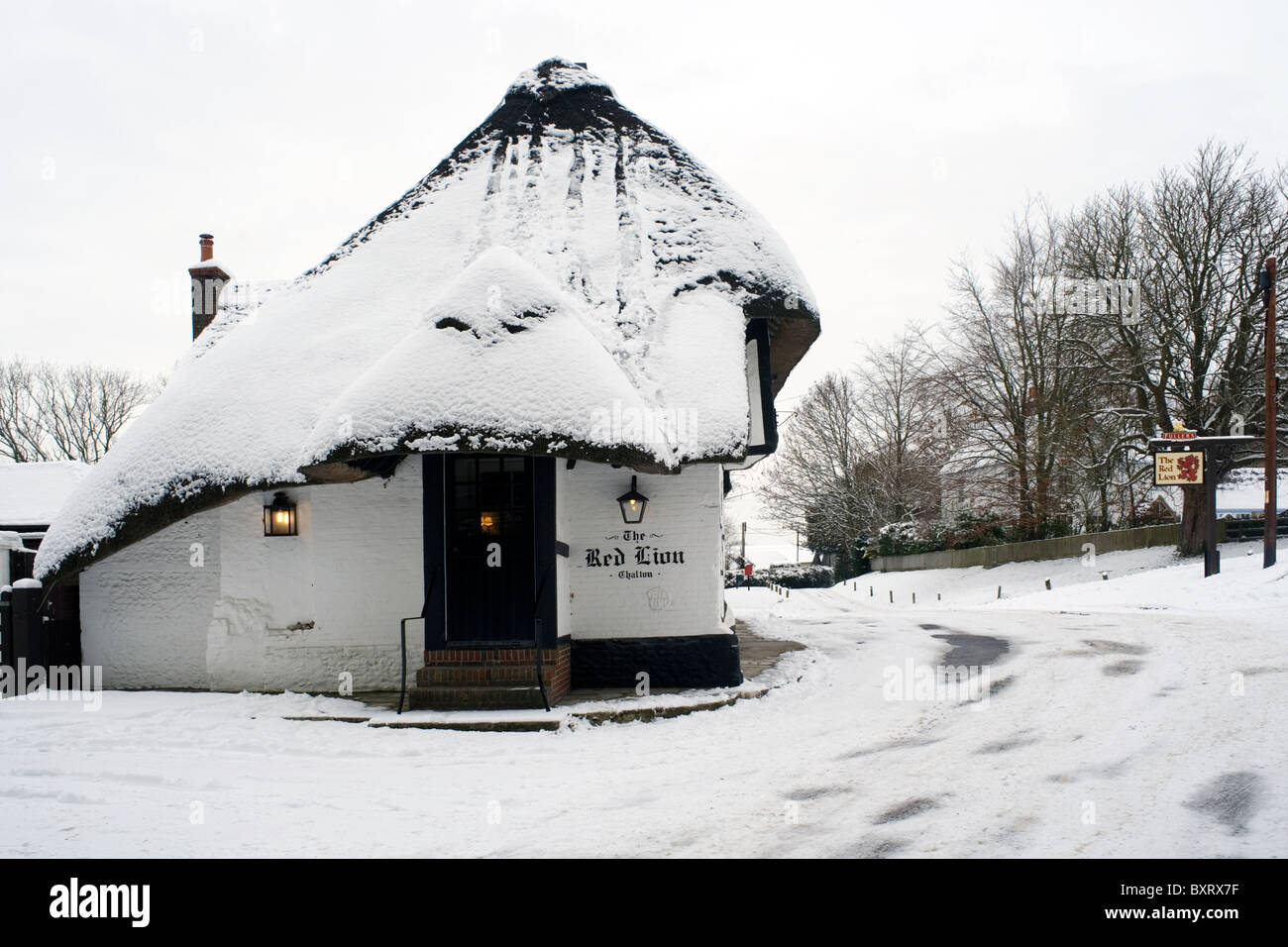 Tradizionali pub con il tetto di paglia nella neve il Red Lion chalton hampshire Inghilterra Foto Stock