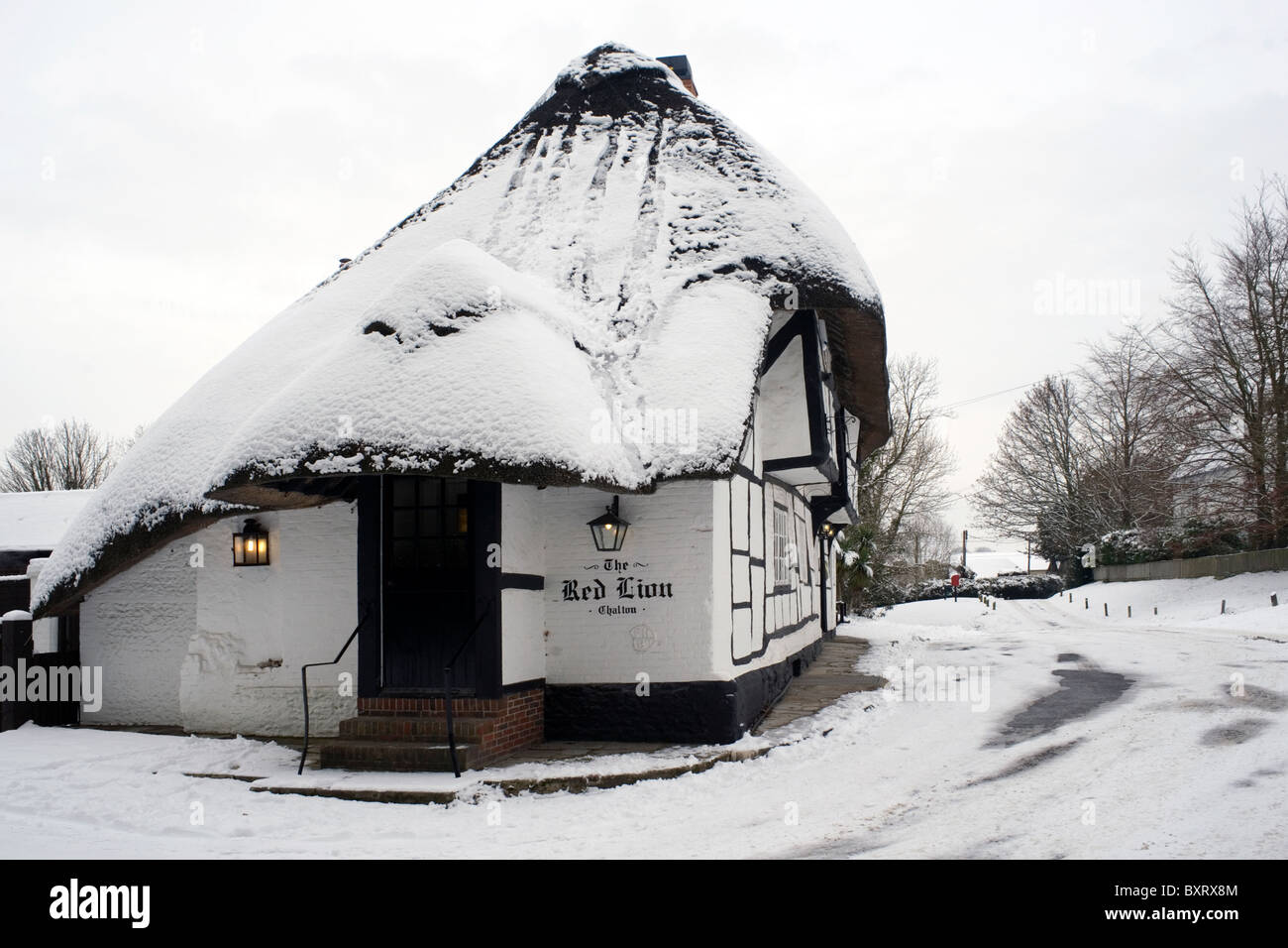 Tradizionali pub con il tetto di paglia nella neve il Red Lion chalton hampshire Inghilterra Foto Stock