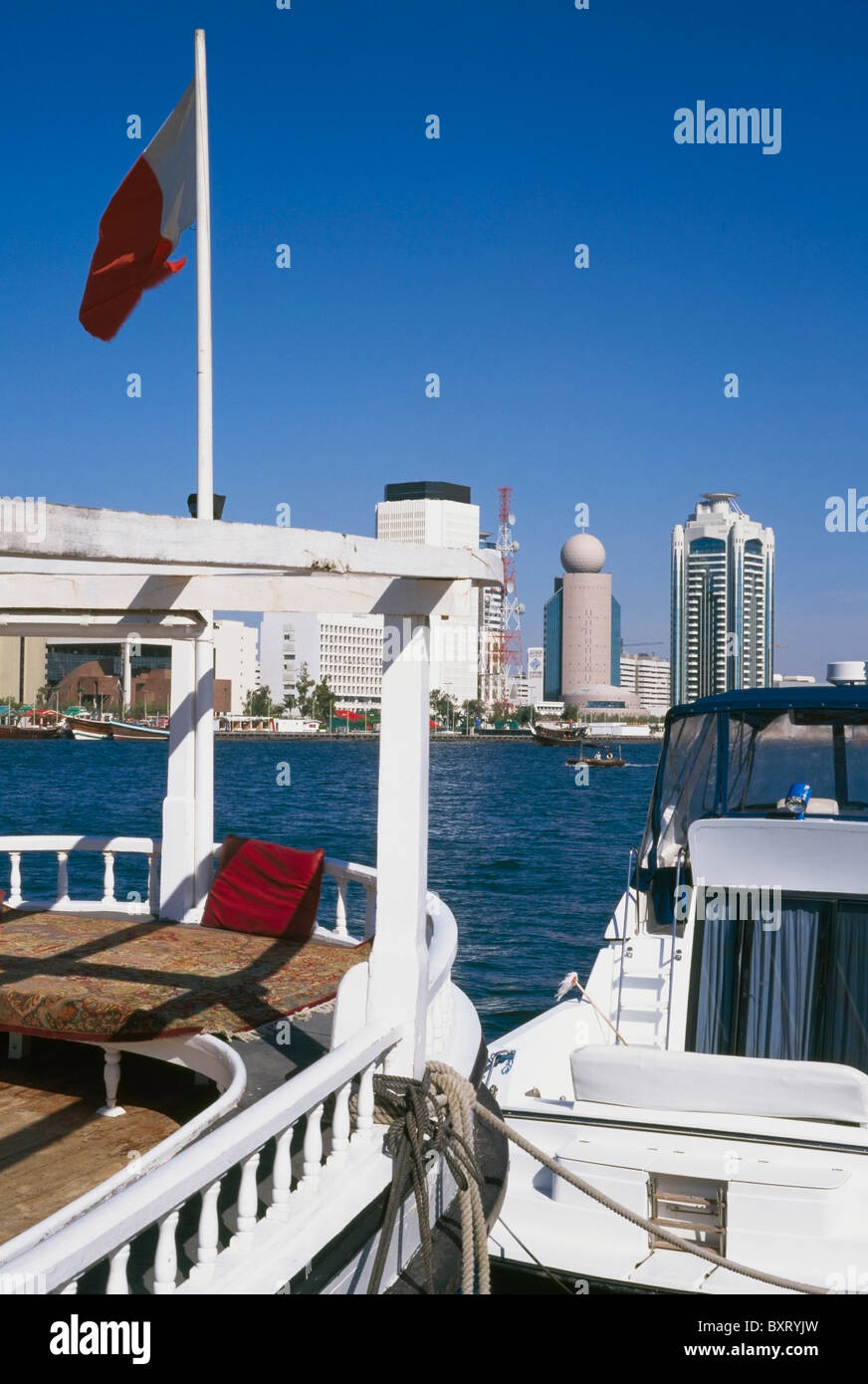 Vista attraverso acqua a Dubai, con barche in primo piano. Foto Stock