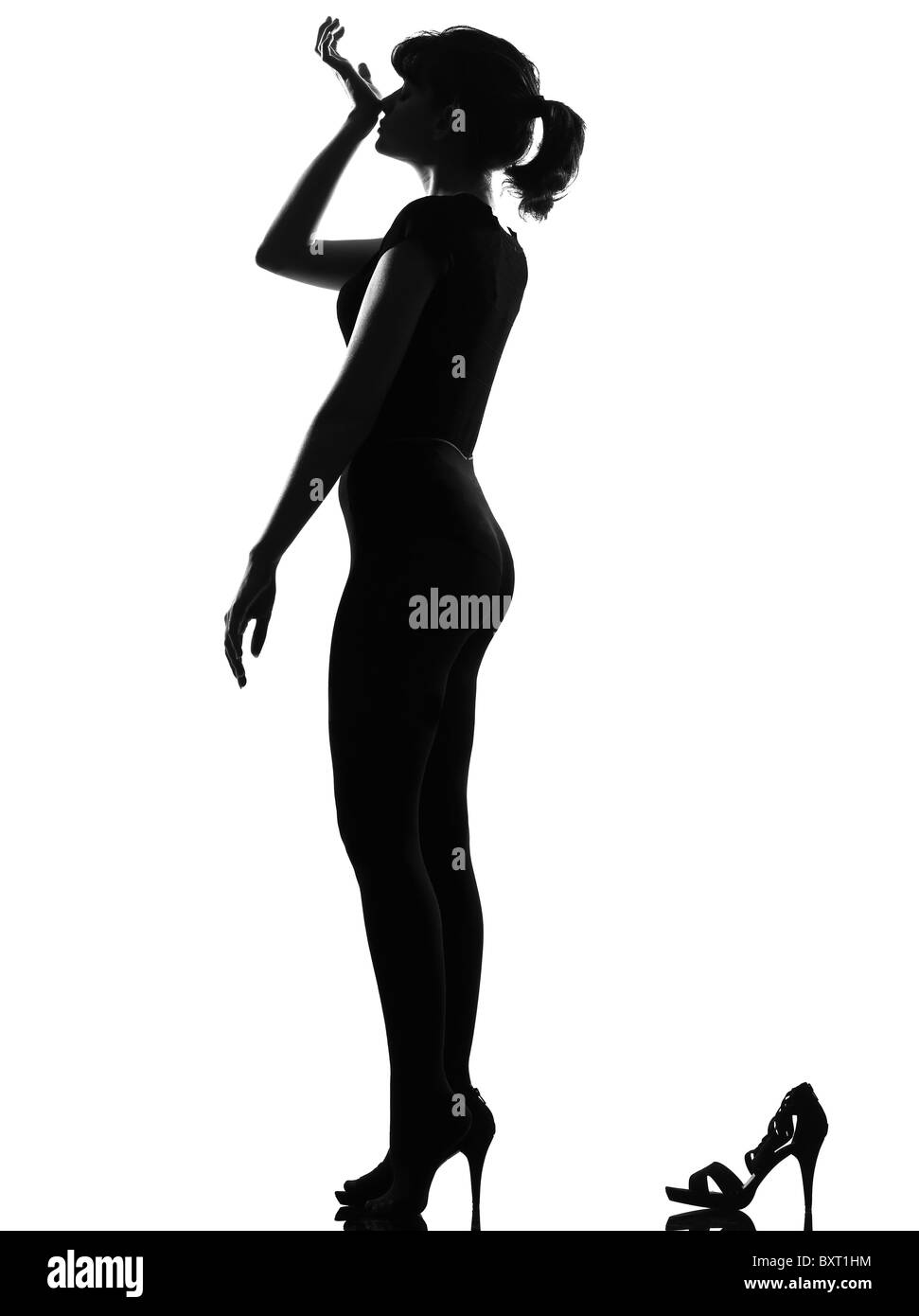 Silhouette in ombra di una giovane donna odore di profumo in studio su sfondo bianco isolato Foto Stock