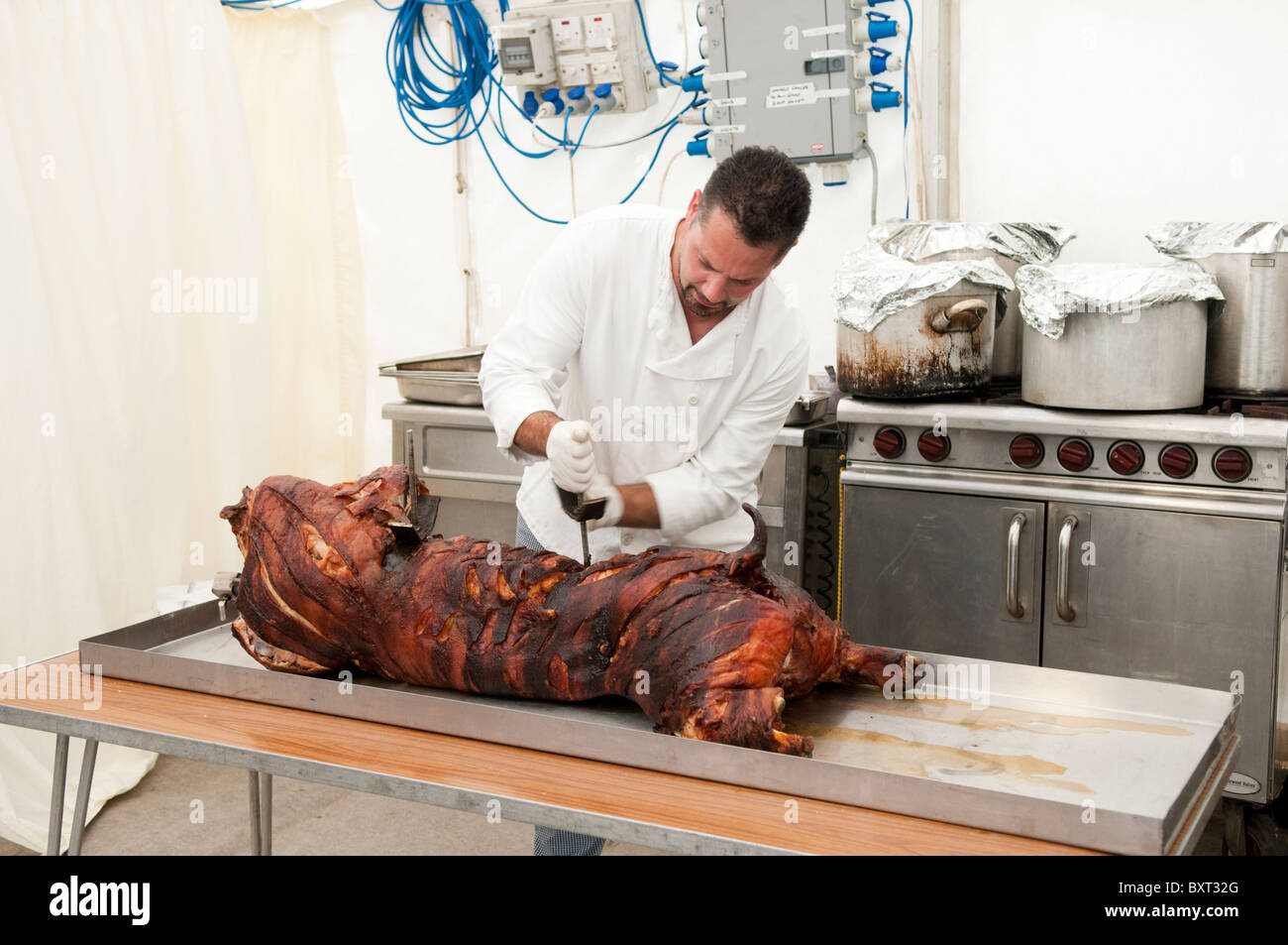 Professionale Chef preparare un arrosto di maiale in una cucina impostato in un rettangolo di selezione Foto Stock