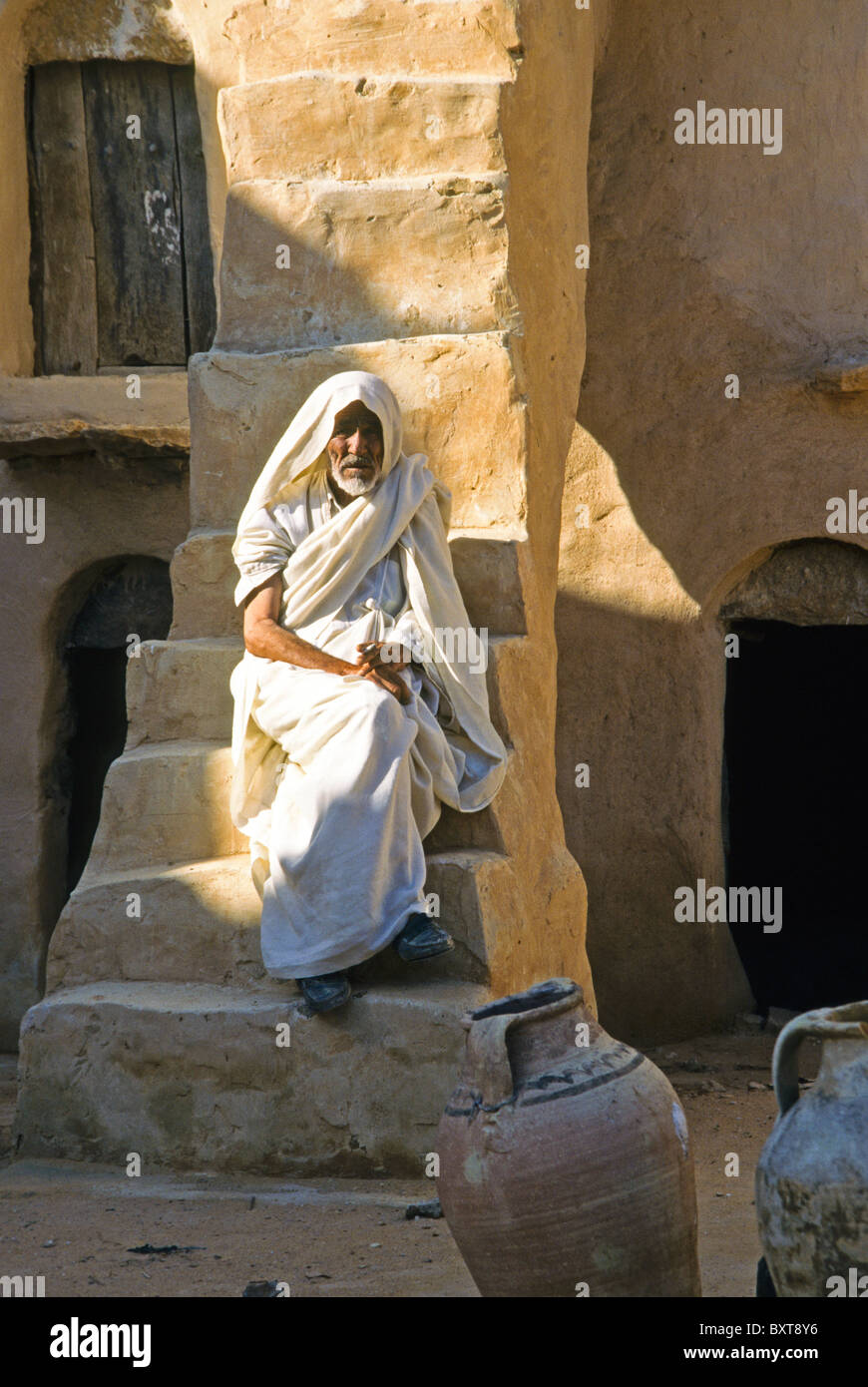 Berber uomo su fasi di ghorfa, Ksar Ouled Soltane, Tunisia Foto Stock