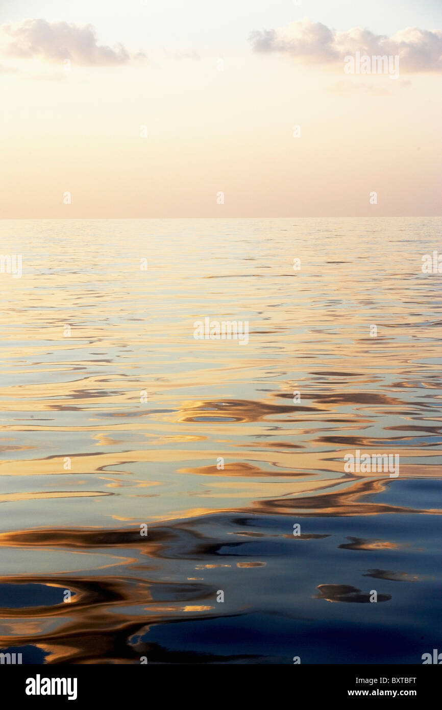 La calma della superficie del mare con il tramonto a basso angolo di visione Foto Stock