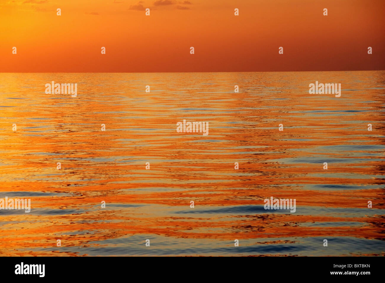Mare calmo con superficie arancione tramonto a basso angolo di visione Foto Stock