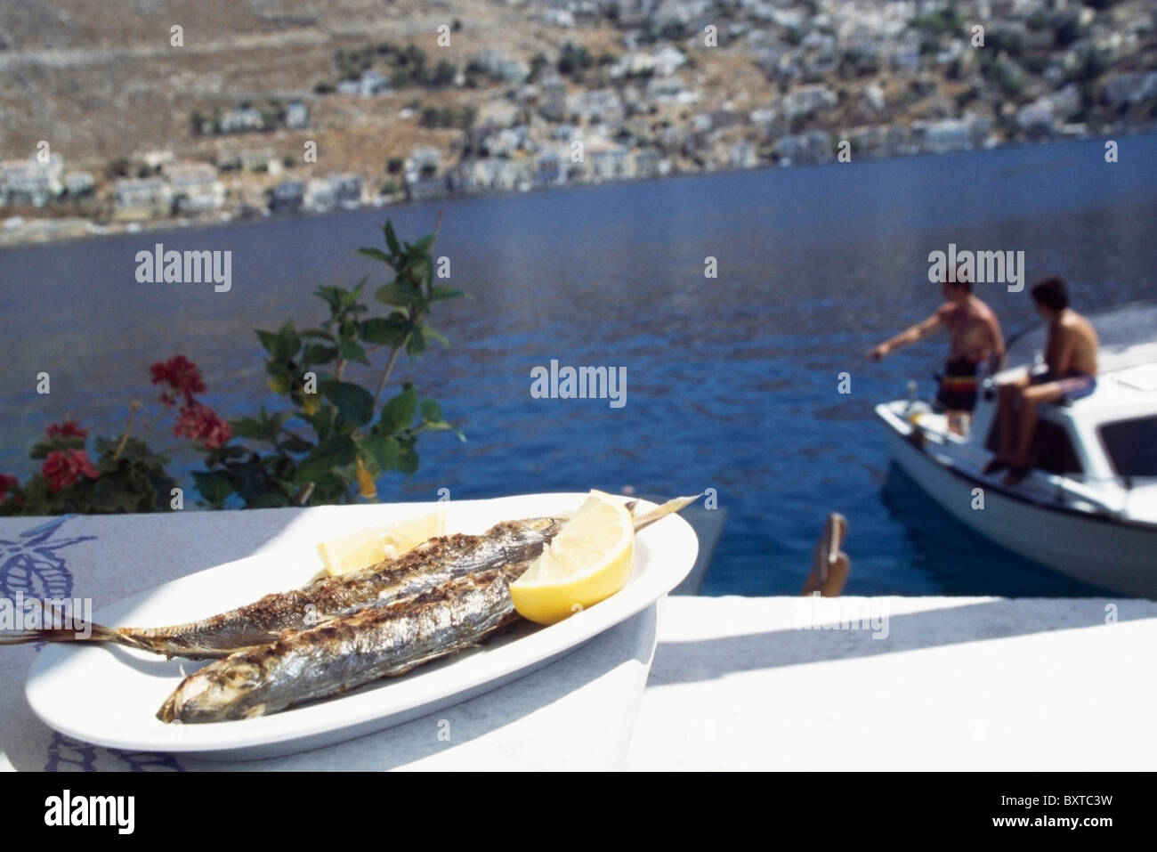 Il cibo sulla piastra e Fisherman Pesca in background Foto Stock